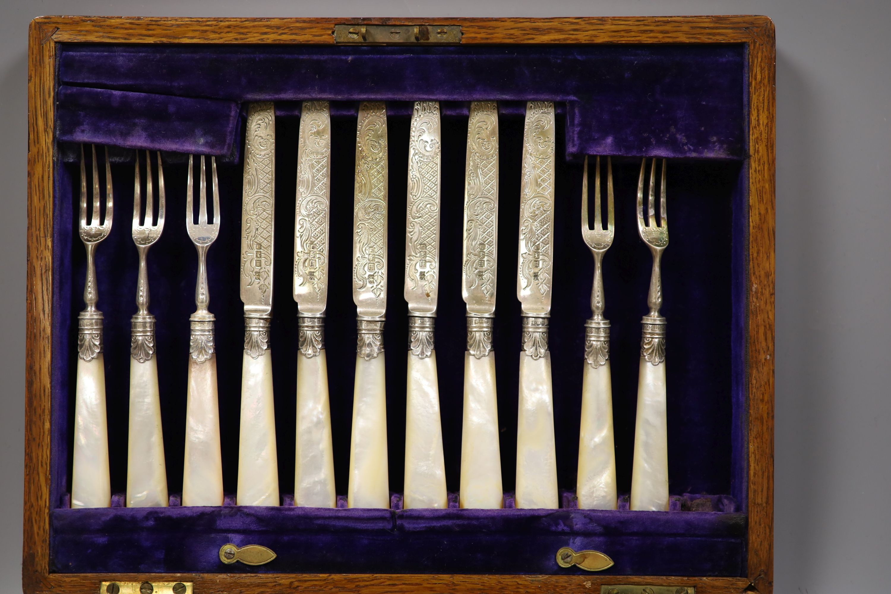 An Edwardian cased set of twelve pairs of mother of pearl handled silver dessert eaters, John Sanderson, Sheffield, 1904.